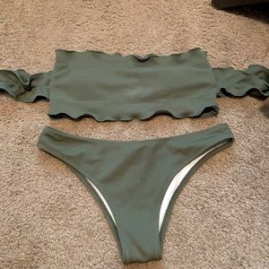 Green bathing suit with off the shoulder sleeves.